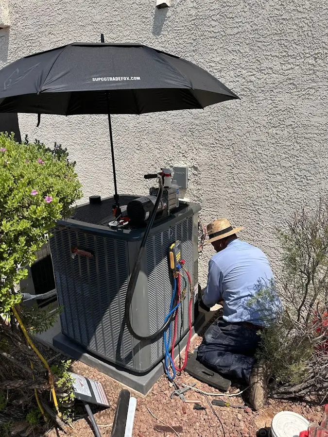 HVAC technician performing outdoor AC maintenance in Del Aire