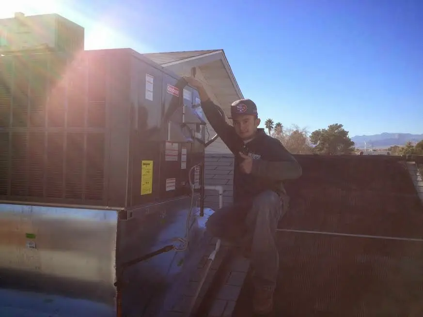 HVAC technician performing Heat Pump Repair on a rooftop unit in Del Aire